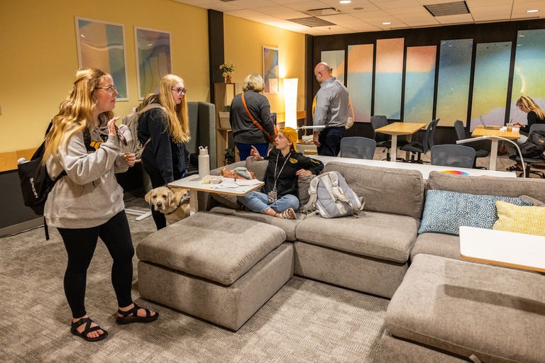 Students and a service dog in the the SDS Lounge, conversing