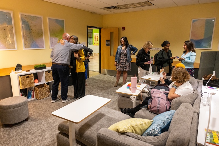 Students and staff mingling in the SDS Lounge on the big couch