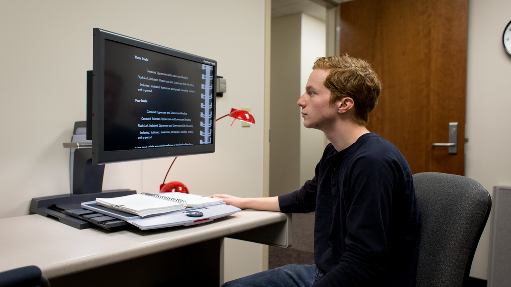 A student using an assistive device with a monitor/screen